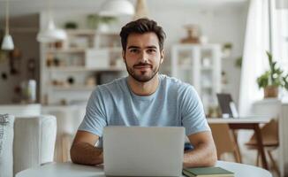 Young man working on a laptop at a modern home office during daylight hours photo