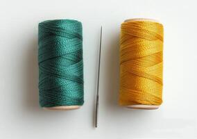 Spools of green and yellow thread with a sewing needle on a light background in a crafting workspace photo