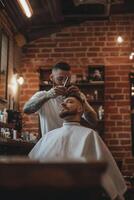 Skilled barber providing a stylish haircut in a vintage barbershop setting during the evening photo