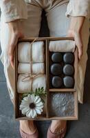 Relaxing spa essentials with towels, stones, and flower at a tranquil setting photo
