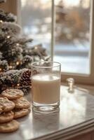 Cozy holiday setting with cookies and milk beside a snow covered window during winter photo