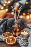 Warm cozy setting with diffuser, candle, and dried orange slices for relaxation photo