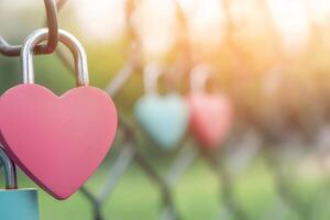Heart shaped padlock hangs on a fence in a park symbolizing love and unity in springtime light photo