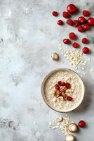 Breakfast bowl with oatmeal, berries, and nuts on a textured surface photo