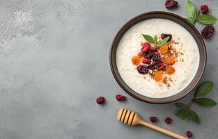 Healthy breakfast bowl with oatmeal and mixed dried fruits on gray background photo
