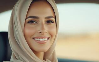 Smiling woman wearing a headscarf in a car with a bright background during daytime photo
