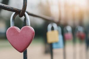 Heart shaped padlock hangs on a fence in a park symbolizing love and unity in springtime light photo