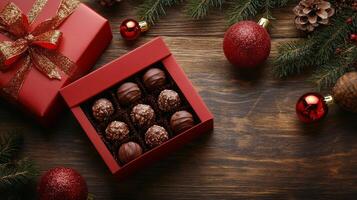 Festive chocolate truffles in a red box surrounded by Christmas decorations photo