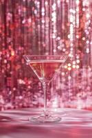 Sparkling cocktail on a decorative table with shimmering pink background at a festive gathering photo