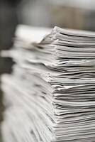 Close up view of stacked white paper sheets in an office workspace during daylight hours photo