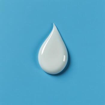 Droplet of cream on a light blue background demonstrating texture and color contrast photo