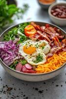Fresh salad bowl with vegetables, bacon, and soft boiled eggs served in a restaurant photo