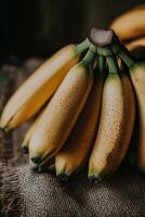 Bananas stacked on burlap fabric in a warm, rustic setting with natural lighting photo