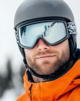 Male skier with goggles and helmet enjoying winter sport in snowy mountain landscape photo