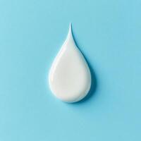 Droplet of cream on a light blue background demonstrating texture and color contrast photo