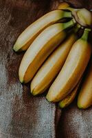 Bananas stacked on burlap fabric in a warm, rustic setting with natural lighting photo