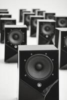 Collection of black speakers arranged in a geometric pattern on a neutral background photo