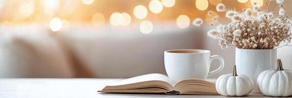 Cozy coffee and open book with flowers on a warm, inviting table in autumn photo