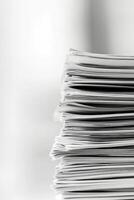 Close up view of stacked white paper sheets in an office workspace during daylight hours photo