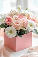 Beautiful bouquet of pink roses and white daisies in a rose gold box on a bright surface photo