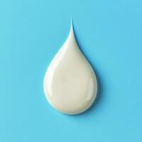 Droplet of cream on a light blue background demonstrating texture and color contrast photo