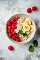 Breakfast bowl with oatmeal, berries, and nuts on a textured surface photo
