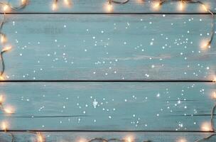 Festive string lights arranged on rustic wooden background for holiday decoration photo