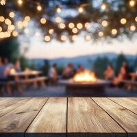 Evening gathering around a fire with string lights illuminating the outdoor setting at dusk photo