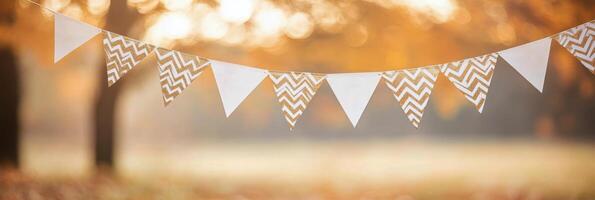 Colorful decorative bunting hanging in a sunlit park during a warm afternoon gathering photo
