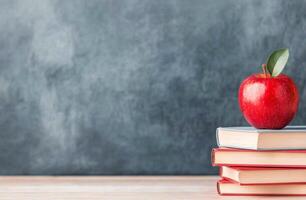 A stack of books with a red apple on top against a blue background in a learning environment photo