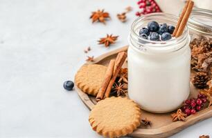 Creamy yogurt with blueberries and spices served with cookies on a wooden tray photo