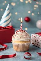 Festive cupcake with candle surrounded by gifts and decorations for a celebration photo