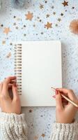 Creating festive art in a cozy setting with a blank notebook and decorative stars photo