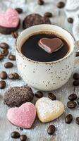 Warm cup of coffee served with heart shaped chocolate on a gray surface with coffee beans photo