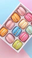Colorful macarons arranged in a box on pastel background for a sweet treat display photo