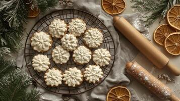 Beautifully decorated winter themed cookies arranged on a wire rack with dried oranges photo