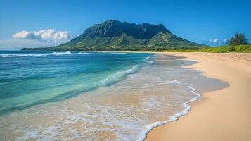 Waves gently lapping on a sandy beach with a mountain backdrop on a clear day photo