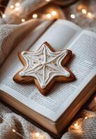 A star shaped cookie decorated with intricate white icing sits atop an open book photo