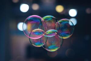 Group of soap bubbles floating showing iridescent colors with blurred background lights photo