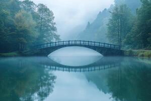 Old stone bridge reflecting in misty lake during autumn photo
