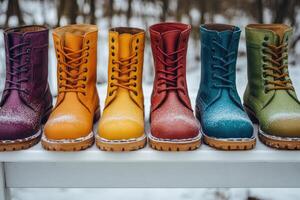 Colorful winter boots covered with snow resting on bench photo