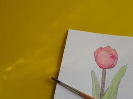 Drawing pastel minimalist pink tulips on paper with yellow background about art education photo