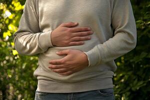 A person with a stomach ache. holding their stomach in pain. on white background. with white space photo