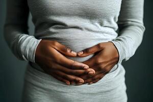 A black person with a stomach ache. holding their stomach in pain. on white background. with white space photo