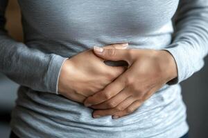 A person with a stomach ache. holding their stomach in pain. on white background. with white space photo