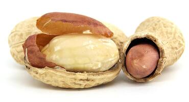 Close-Up of Whole and Shelled Peanuts on White Background photo