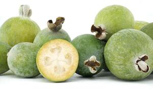 Fresh Green Feijoa Fruit Pile with Halved Juicy Slices Displayed photo