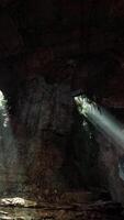 A mesmerizing cave illuminated by a beam of ethereal light in the mountains video