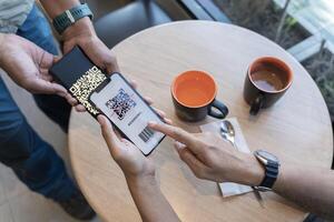 Focus on Scan here to pay text. Close up of hands Scaning QR code for digital contact less payment after shopping. photo