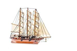 Detailed miniature of a classic sailing ship, showcasing intricate rigging and sails, set against a white background. photo
